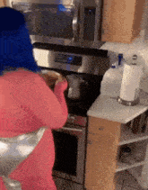 a woman with blue hair is standing in front of a stove