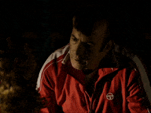 a man in a red jacket with the letter t on the sleeve