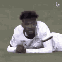 a soccer player is laying on his stomach on the ground .