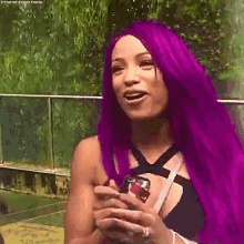 a woman with purple hair is holding a can of soda and smiling .