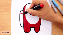 a person is drawing an among us character with a marker