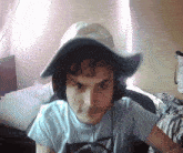a young man wearing a hat and headphones looks at the camera