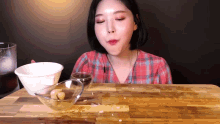 a woman is sitting at a table with bowls of food and a glass of cola