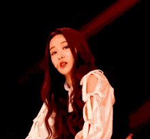 a woman with long red hair is wearing a white top