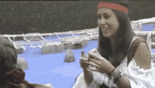 a woman wearing a red headband and bracelets is smiling