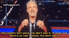 a man with a beard is giving a speech on a television show .