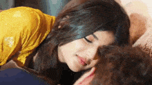 a woman is kissing a man on the forehead .