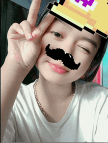 a girl wearing a fake mustache and a pixelated e on her forehead