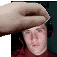 a man wearing headphones and a red shirt is being touched by a person 's hand .