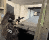 a woman wearing headphones is holding a rifle in a shooting range