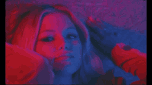 a close up of a woman 's face with red and blue lights