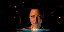a woman 's torso is covered in flames against a black backdrop