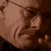 a close up of a man wearing glasses making a face
