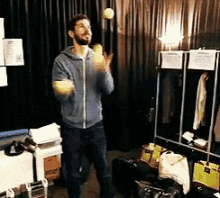 a man is standing in a room holding a tennis ball in his hands