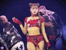 a woman in a red crop top and shorts is dancing on stage
