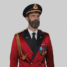 a man with a beard is wearing a red jacket and a black hat