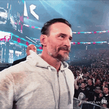 a man with a beard stands in front of a crowd with a sign that says ck-purr
