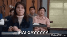 a woman is sitting in a classroom with a group of people and says `` ha ! gay ! ''