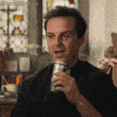 a man in a black shirt is holding a can of soda in his hand with the hashtag @itsscottlesstark visible in the corner