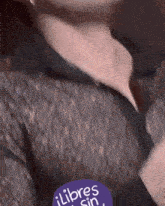 a close up of a person 's neck with a purple sticker that says libres sin