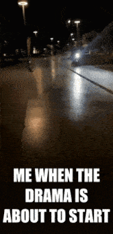 a motorcycle is driving down a street at night with a caption that says me when the drama is about to start .