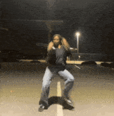 a girl is dancing in a parking lot at night .