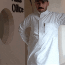 a man stands in front of a wall that says office