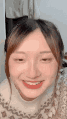 a close up of a woman 's face with her eyes closed and a smile on her face .
