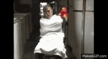 an elderly woman is wrapped in a white sheet and holding a stuffed animal .