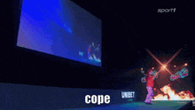 a man is dancing in front of a large screen that says peter cope