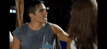 a man and a woman are talking to each other while a man holds a woman 's arm .