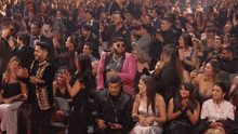 a man in a pink jacket is surrounded by a crowd