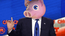 a man in a suit and tie wearing a pig mask giving the middle finger