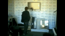 a man is standing in a room with a piano and a television