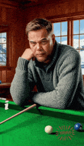 a man leans against a pool table with a sticker that says yayah