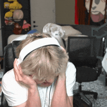 a man wearing headphones is sitting in a chair with his head in his hands