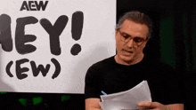 a man stands in front of a sign that says hey ew