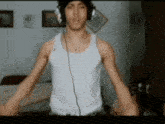 a man wearing headphones and a tank top is dancing
