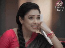 a woman with a red dot on her forehead is smiling and holding a piece of paper with the words sami gifs above her