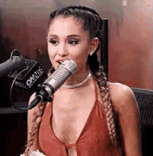 ariana grande is sitting in front of a microphone .
