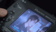 a person is taking a picture of a man on a camera .