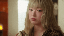 a woman with blonde hair is wearing a leopard print jacket