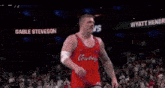 a wrestler is holding an american flag on a wrestling mat