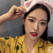 a woman wearing a yellow pajama top with pineapples on it