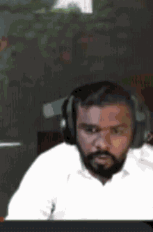 a man with a beard is wearing headphones and looking at something