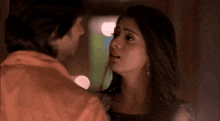 a man and a woman are kissing each other in a dark room .
