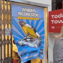 a sign for wheelin 's record store is hanging on a door