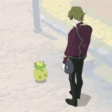 a man is walking down a sidewalk next to a small green plant .
