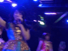 a woman singing into a microphone in front of a crowd of people