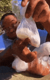 a man wearing glasses is holding a bag of food in his hand .